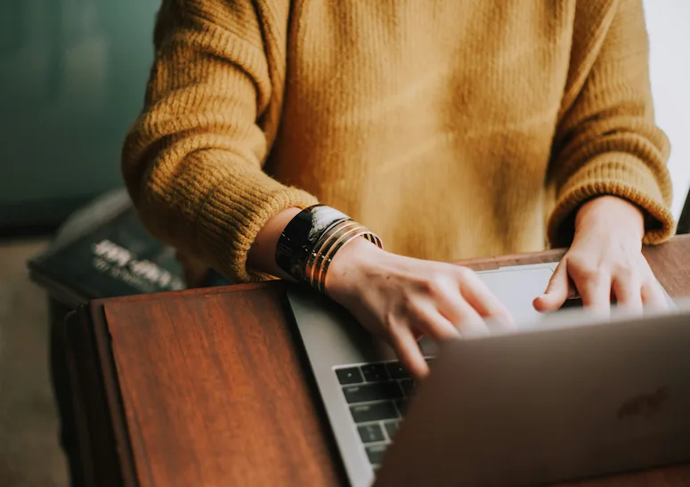 A woman typing on her laptop, immersed in her work related to digital marketing.